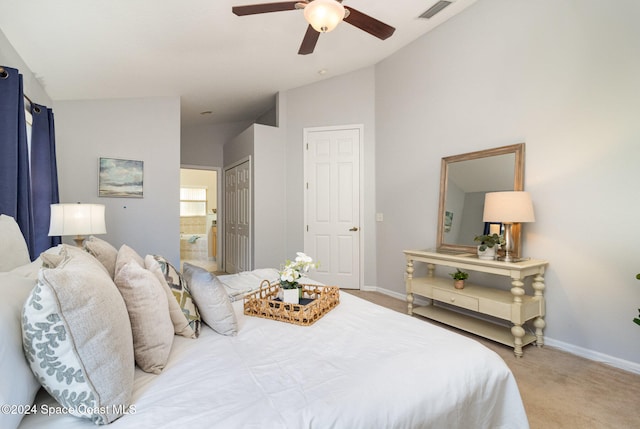 bedroom featuring ensuite bath, ceiling fan, light colored carpet, and lofted ceiling