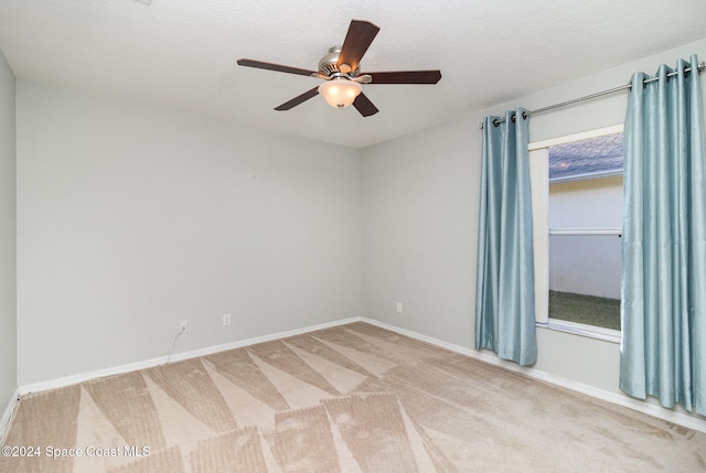 carpeted empty room with ceiling fan and a textured ceiling