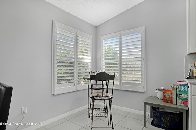 tiled office with lofted ceiling, a textured ceiling, and a healthy amount of sunlight