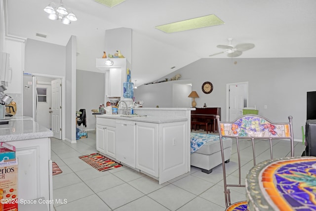 kitchen featuring white cabinets, ceiling fan with notable chandelier, light tile patterned floors, and vaulted ceiling