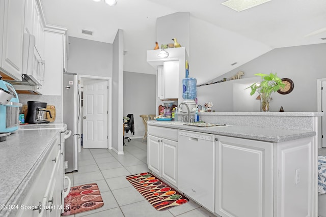 kitchen featuring light tile patterned flooring, white cabinetry, sink, white appliances, and lofted ceiling