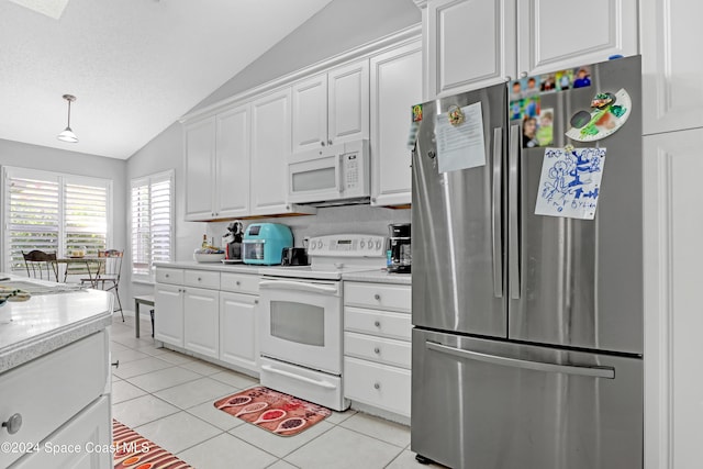 kitchen with lofted ceiling, white cabinets, a textured ceiling, light tile patterned floors, and white appliances