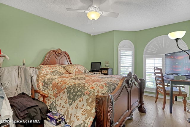 bedroom featuring a textured ceiling, light hardwood / wood-style floors, and ceiling fan