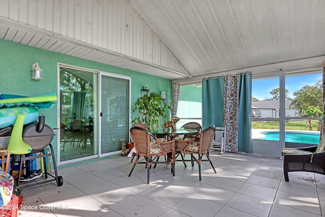 sunroom / solarium featuring vaulted ceiling