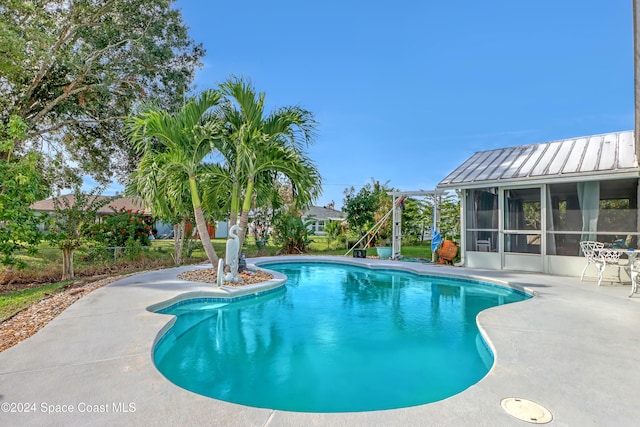 view of swimming pool featuring a patio and a sunroom