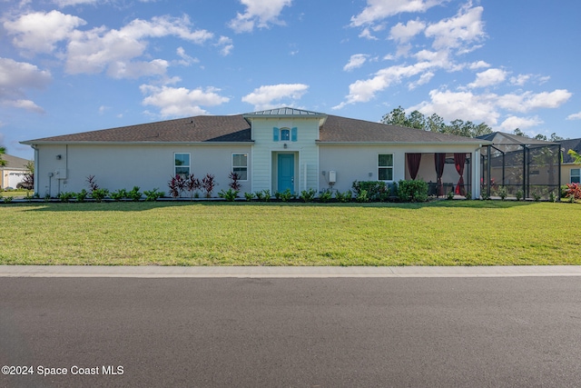 view of front of home with a front lawn and a lanai