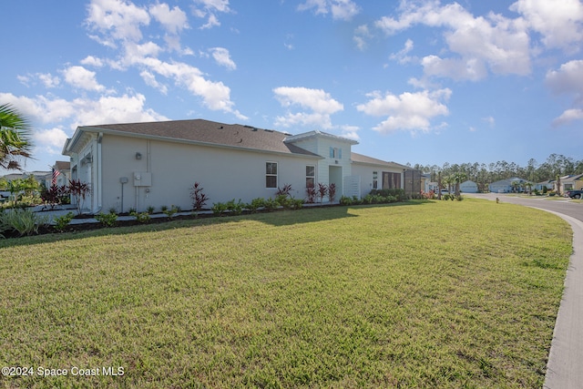 view of side of home with a yard