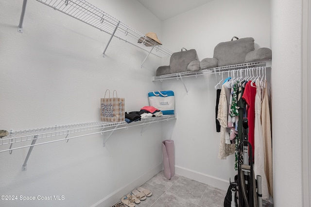 walk in closet with light tile patterned floors