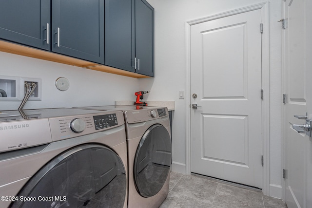 clothes washing area featuring washer and dryer and cabinets