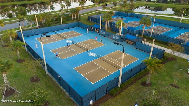 view of sport court with a water view and tennis court