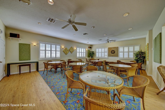dining space featuring visible vents, a ceiling fan, light wood-style floors, and baseboards