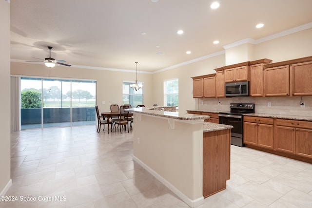 kitchen with appliances with stainless steel finishes, a healthy amount of sunlight, decorative light fixtures, and light stone counters