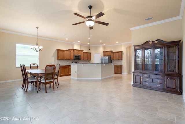 kitchen featuring a kitchen island, stainless steel appliances, ornamental molding, a breakfast bar, and ceiling fan with notable chandelier