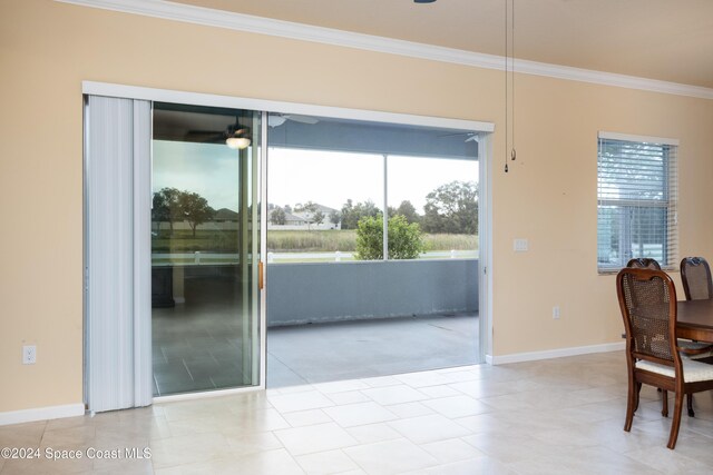 interior space featuring a healthy amount of sunlight, baseboards, ornamental molding, and ceiling fan