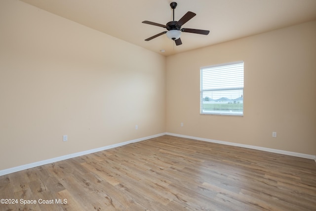spare room with a ceiling fan, baseboards, and light wood-type flooring