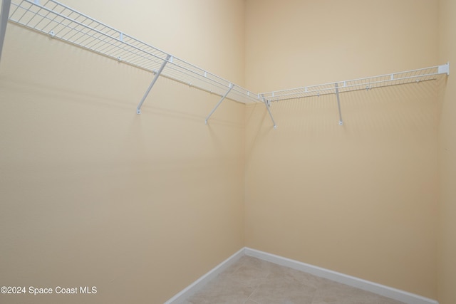 walk in closet with light tile patterned floors