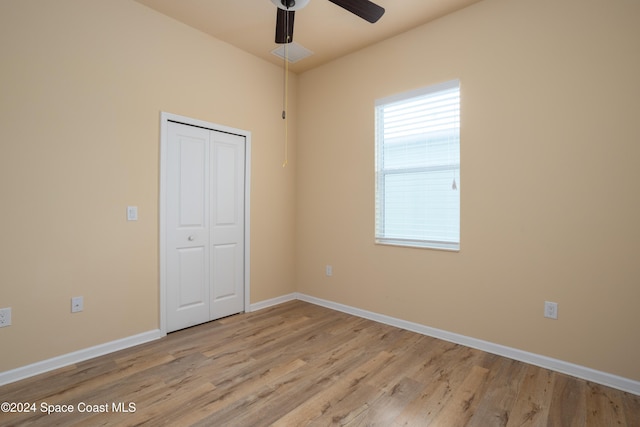 unfurnished bedroom with a closet, baseboards, ceiling fan, and wood finished floors
