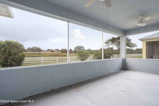 unfurnished sunroom with ceiling fan