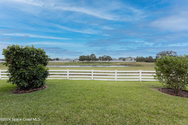 view of yard featuring fence and a water view