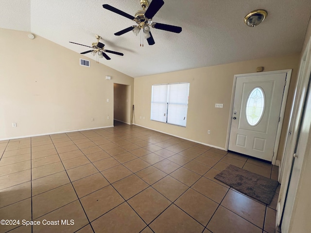 tiled foyer featuring a textured ceiling, ceiling fan, and lofted ceiling