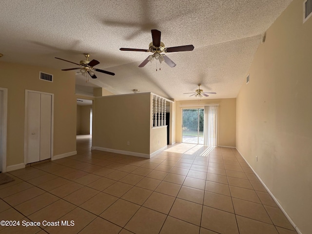 spare room featuring ceiling fan, light tile patterned floors, a textured ceiling, and vaulted ceiling