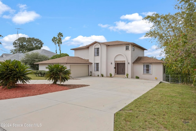 mediterranean / spanish-style home with a garage and a front lawn