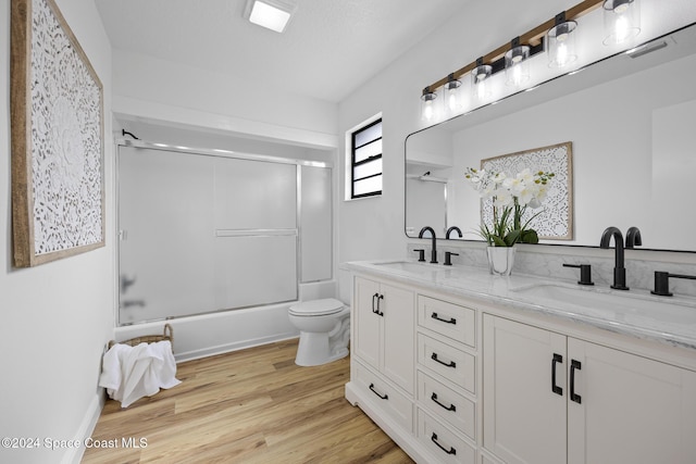 750 W Whitmire Dr, Melbourne, FL 32935 - full bath featuring double vanity, toilet, bath / shower combo with glass door, and wood finished floors