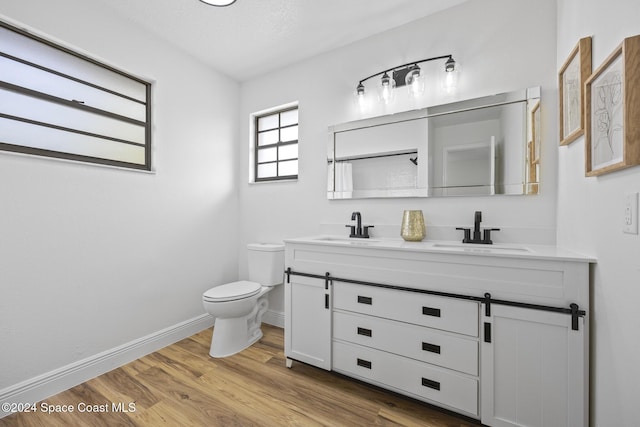 750 W Whitmire Dr, Melbourne, FL 32935 - full bathroom featuring double vanity, toilet, baseboards, and wood finished floors