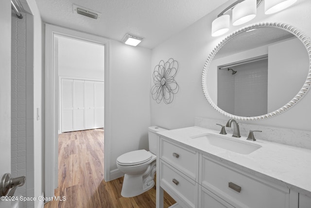 bathroom featuring toilet, vanity, a textured ceiling, and hardwood / wood-style flooring