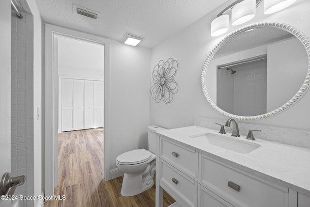 750 W Whitmire Dr, Melbourne, FL 32935 - bathroom featuring vanity, wood finished floors, a textured ceiling, and toilet