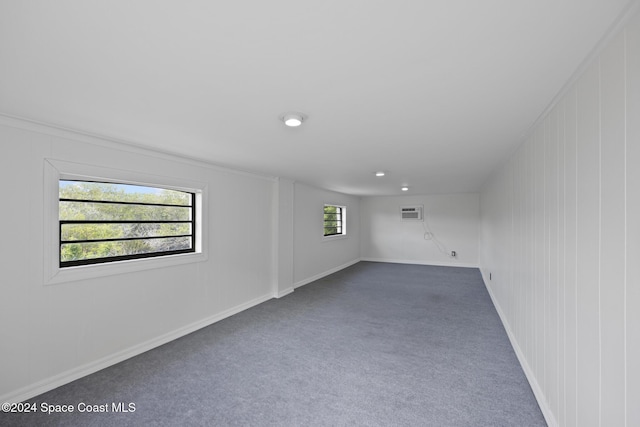 750 W Whitmire Dr, Melbourne, FL 32935 - spare room featuring dark colored carpet, a wall mounted air conditioner, and baseboards