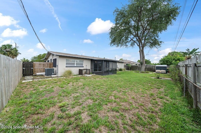 exterior space with a sunroom, cooling unit, and a lawn