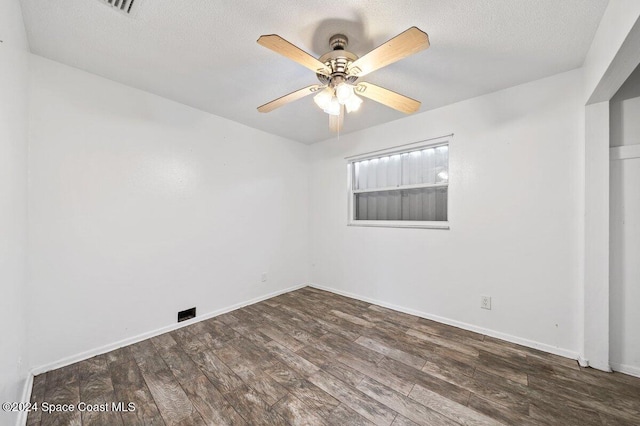 empty room with dark hardwood / wood-style floors, ceiling fan, and a textured ceiling