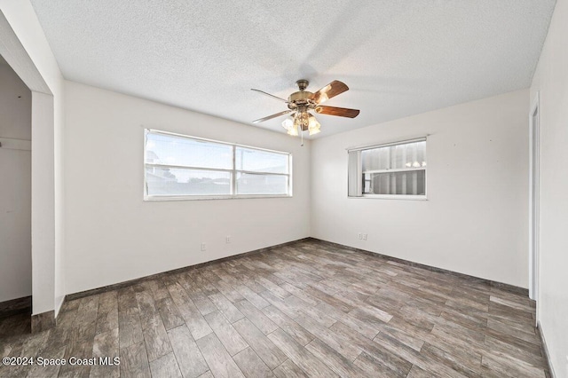 unfurnished bedroom with ceiling fan, a closet, wood-type flooring, and a textured ceiling