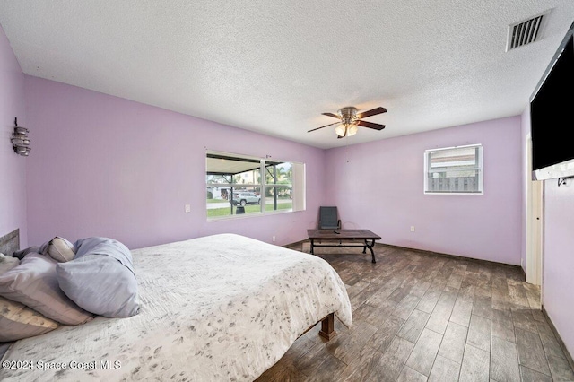 bedroom featuring a textured ceiling, hardwood / wood-style flooring, and ceiling fan