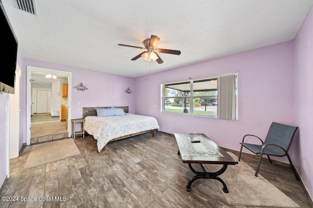 bedroom featuring hardwood / wood-style floors, a textured ceiling, and ceiling fan