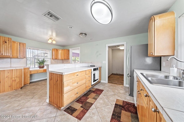 kitchen with light tile patterned flooring, black electric stovetop, oven, and sink