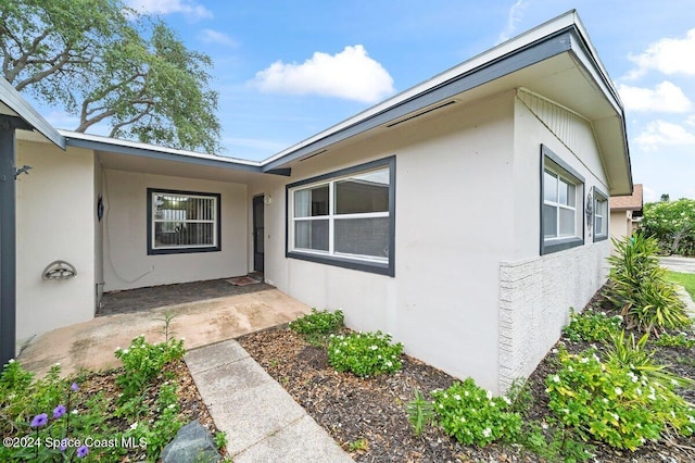 view of exterior entry with a patio area