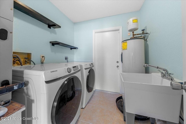 laundry area featuring independent washer and dryer, water heater, sink, and light tile patterned floors