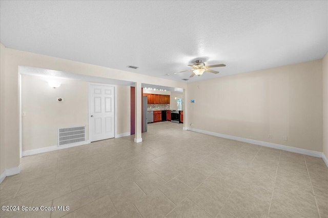 unfurnished living room with a textured ceiling and ceiling fan