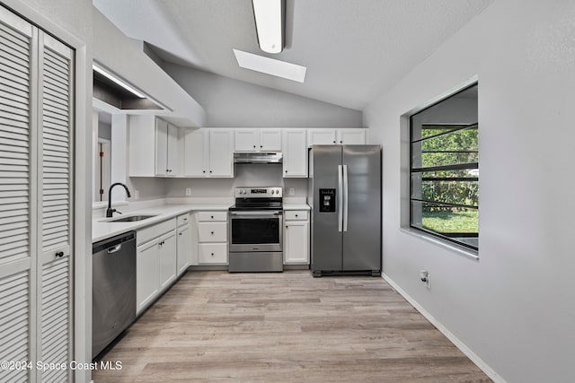 kitchen with appliances with stainless steel finishes, white cabinets, sink, and light hardwood / wood-style floors