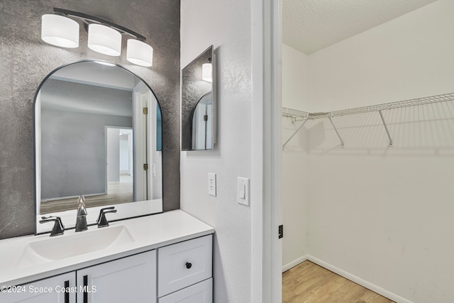 bathroom featuring vanity, a textured ceiling, and hardwood / wood-style flooring