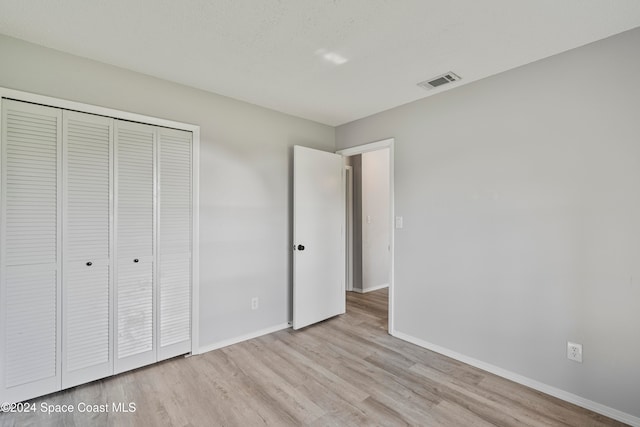 unfurnished bedroom featuring a closet and light hardwood / wood-style floors