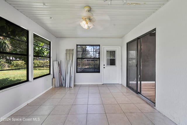 unfurnished sunroom featuring wood ceiling and ceiling fan