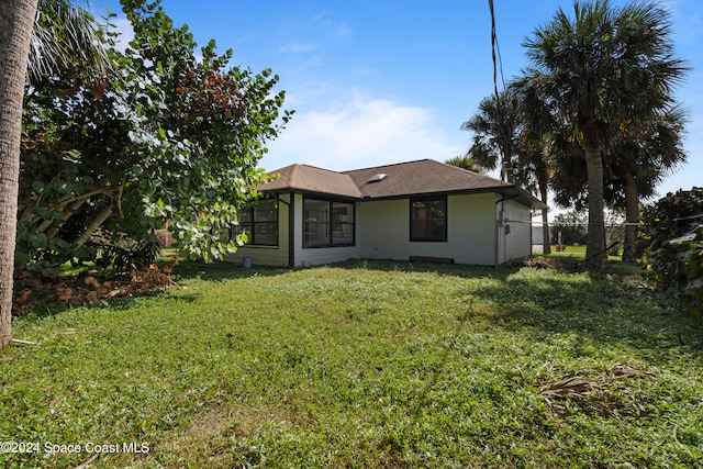 rear view of property featuring a yard and a sunroom