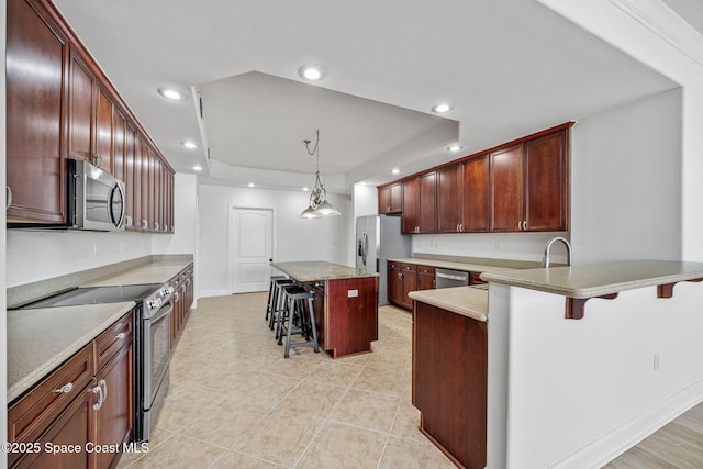 4975 Dixie Hwy NE Unit 201, Palm Bay, FL 32905 - kitchen with appliances with stainless steel finishes, a kitchen bar, recessed lighting, hanging light fixtures, and a raised ceiling