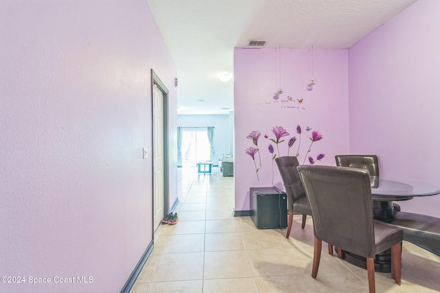 dining room featuring a textured ceiling and light tile patterned flooring