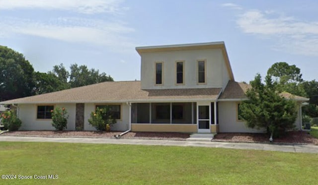 view of front of property with a front yard and a sunroom