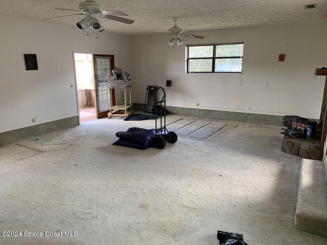 interior space featuring ceiling fan, carpet flooring, and a textured ceiling