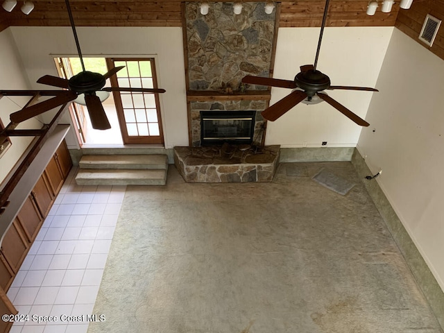 unfurnished living room with a stone fireplace, light tile patterned flooring, high vaulted ceiling, and ceiling fan